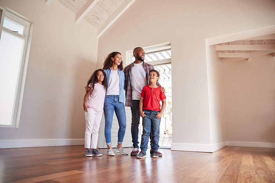 Family Opening Door And Walking In Empty Lounge Of New Home